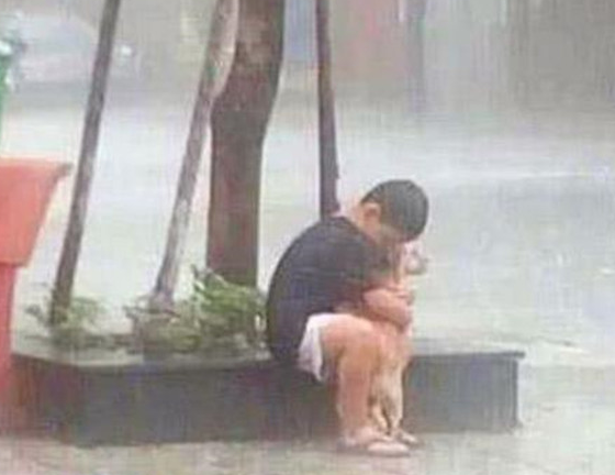 男孩雨中抱着狗狗不放，拒绝进屋避雨，直到一名男子出现才明白 