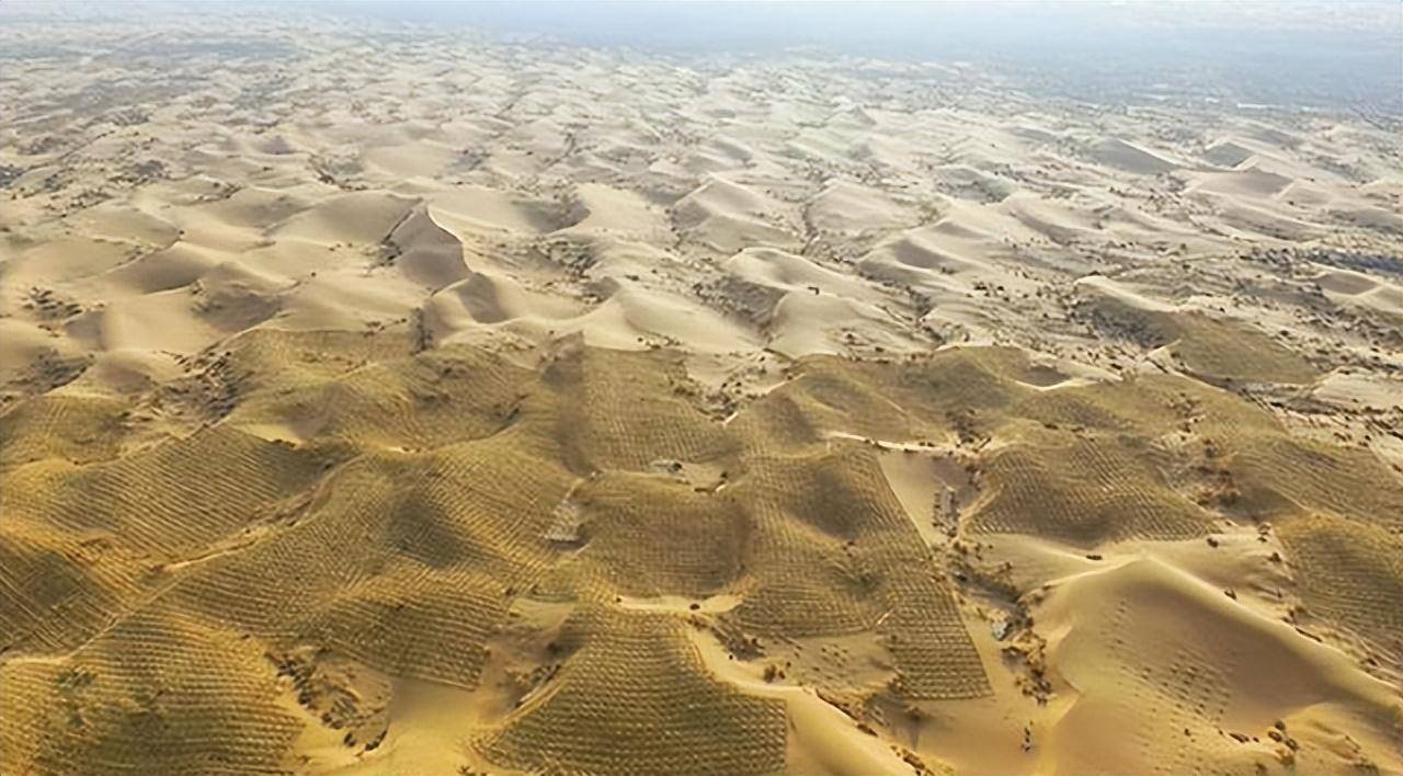 从高空俯瞰,以沙丘链和格状沙丘形态分布的库布齐沙漠在微风轻拂下