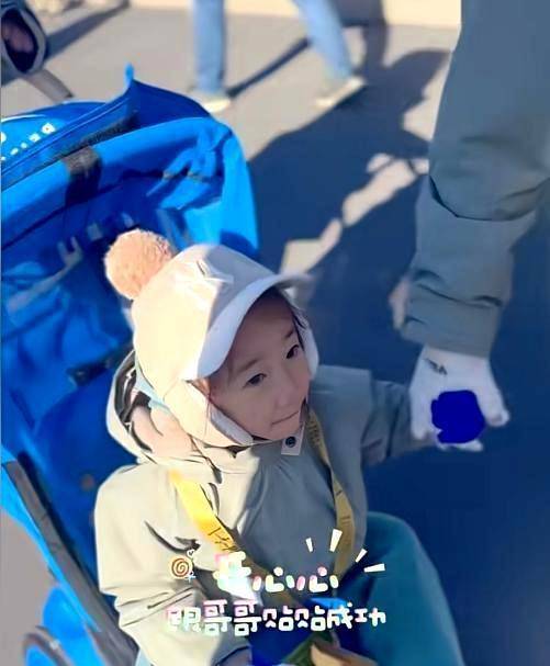 jasper和他的小弟弟穿着相似的衣服,戴着不同颜色但款式相同的帽子.