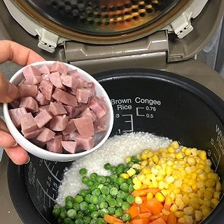 把米洗好,放入电饭煲内,加入一勺盐1,把胡萝卜,台式小香肠切丁,玉米粒