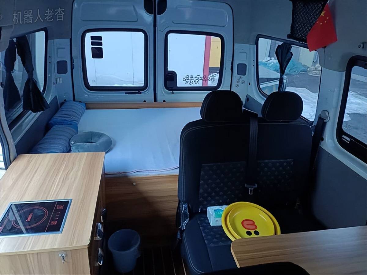 室内铺设了条带pvc地板,前后排座椅之间添置了一张简易折叠桌,中门有