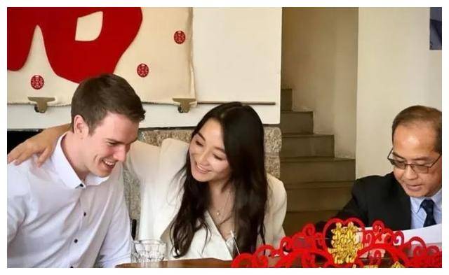 从照片上能看出,梁家辉穿着白色衣服,他的媳妇则穿着黑白色波点衬衫