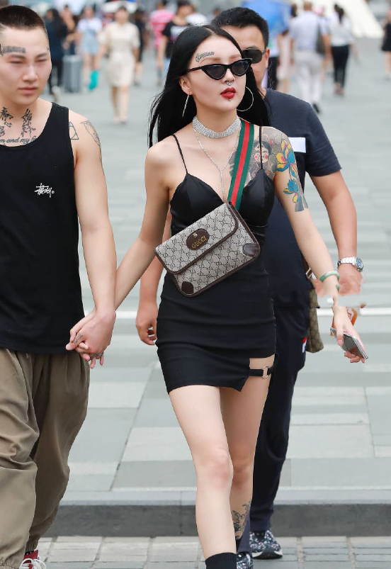 秀出了自己的一双白皙修长的美腿,美女佳人,小腿部位的纹身与手臂上的