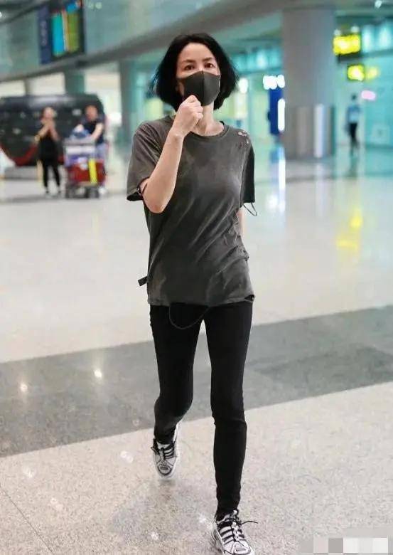 在寺庙前的合影画面中,王菲身着刺绣棉麻衣物,与短发造型相得益彰