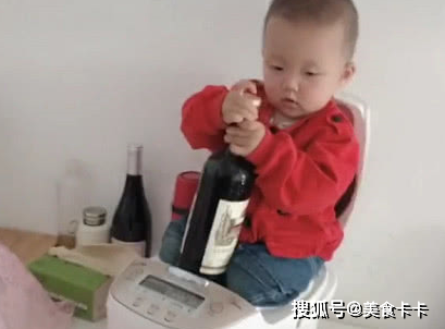 “捣蛋宝宝”蹲在电饭煲里打开红酒。这孩子很安静，一定在做坏事。