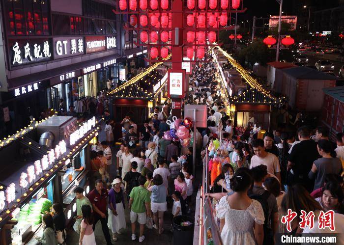 中新社记者 于晶 摄8月4日,宁夏银川,市民在夜市体验套圈游戏.连日