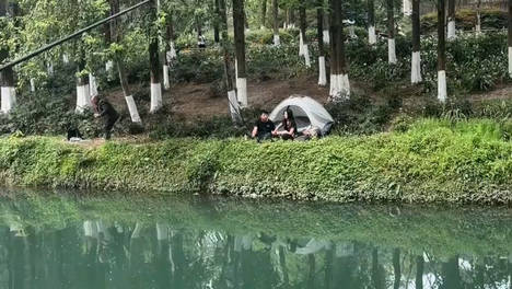 男子钓鱼身边还带着一女子，女子帮他按着手背，路人都羡慕不已