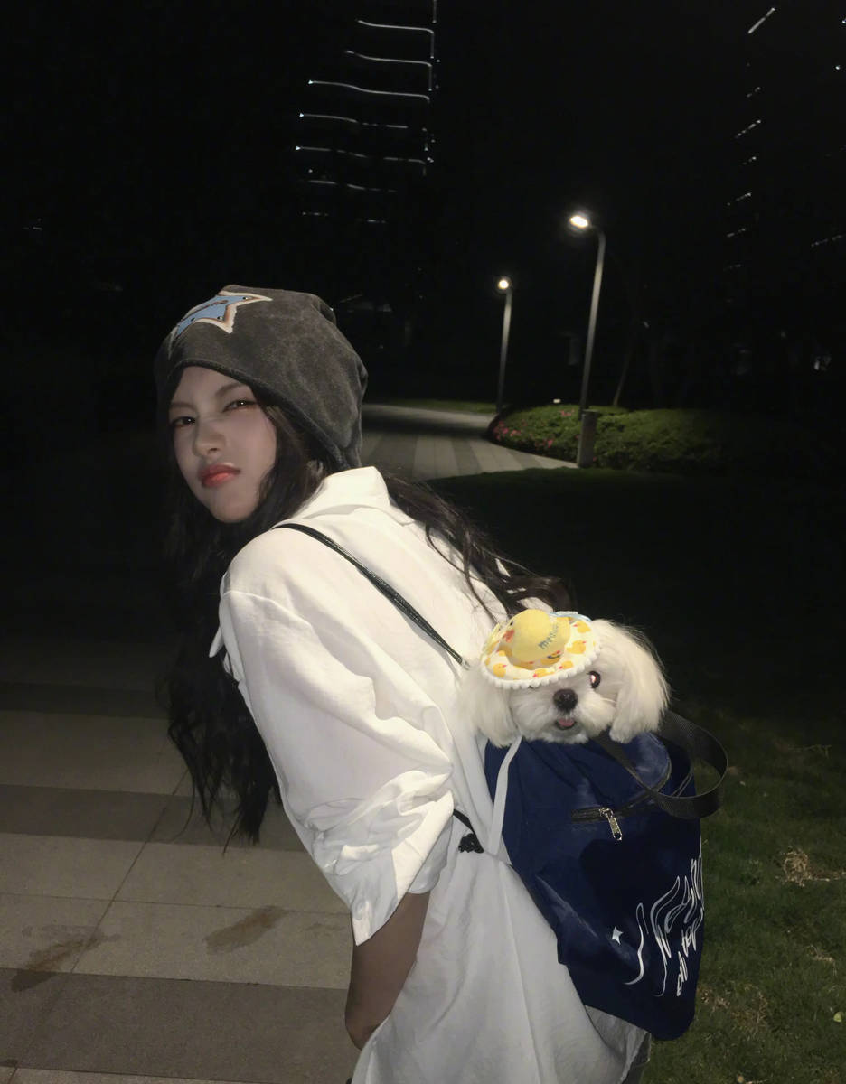 李一桐穿白色卫衣俏皮可爱 背着小狗出门自在随性