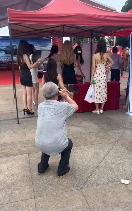 一位大爷去参加车展,不拿手机去给车拍照,却不停给车模拍照