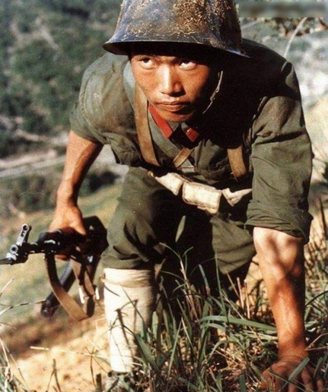 照片这名老兵采取迂回的方式向敌人发起进攻,他戴着钢盔,右手拿着56-1