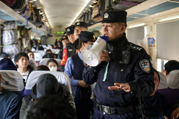 在z69次列车上,张威(右)为一名不慎摔倒的小乘客搽药(1月13日摄).