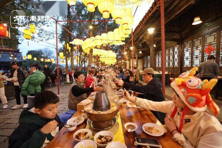 2月13日晚,浙江嘉兴乌镇景区在街巷大摆长街宴,游客边吃着美食,边欣赏