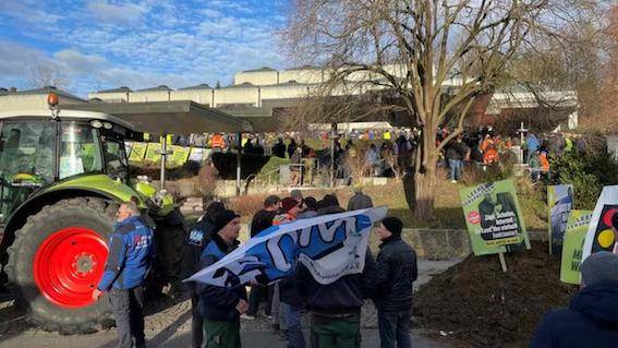 一名男子在一名带着狗的女警察面前持续地摇着牛铃,说, "我现在整天