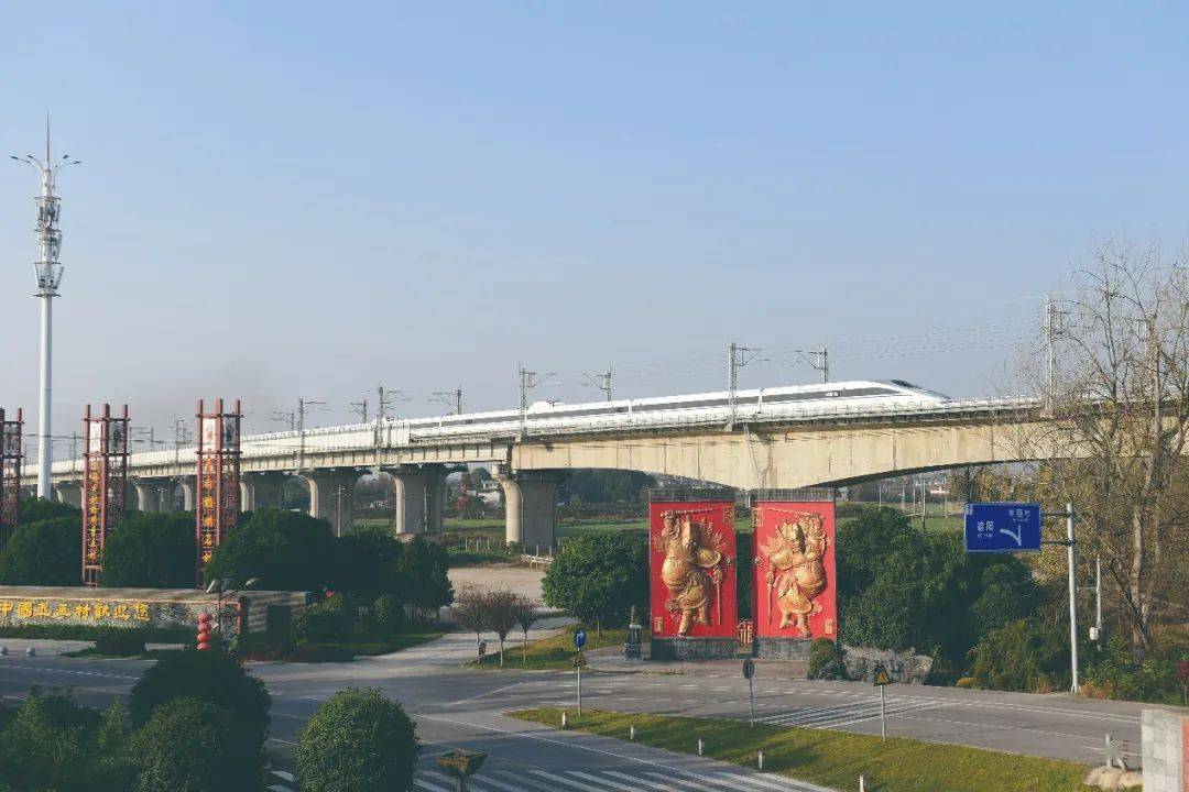 图为动车奔驰在充满 年画特色的绵竹大地上川青铁路绵竹段绵远河特