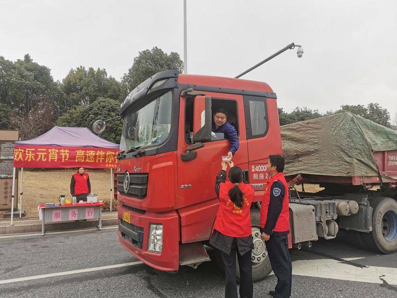 在诸永高速璜山收费站,来自贵州的货车司机王师傅接过志愿者递上的