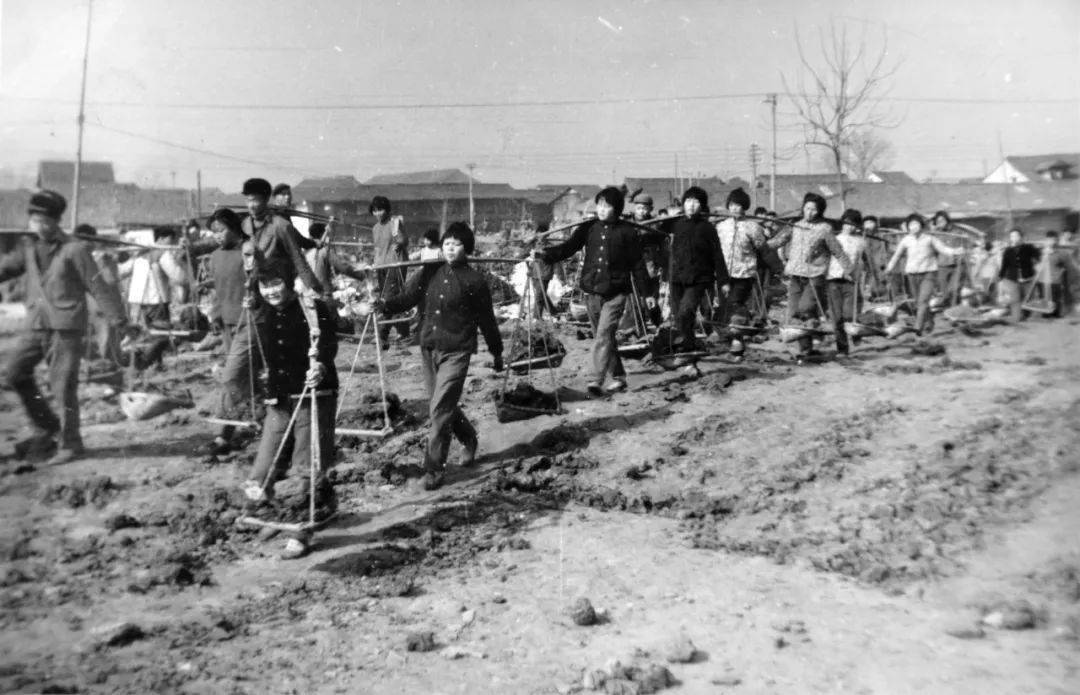 民工在崇福市河工地上挖泥挑土.