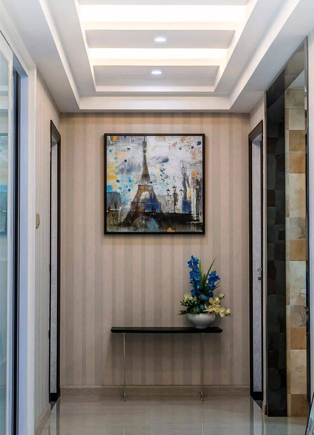 通往卧室,卫生间的走廊过道,在走廊的尽头摆放矮凳子和花盆,墙面铺贴