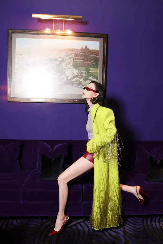 倪妮对荧光色外套搭配安可拉红皮质短裤的演绎,鲜绿穿插在暧昧的深红