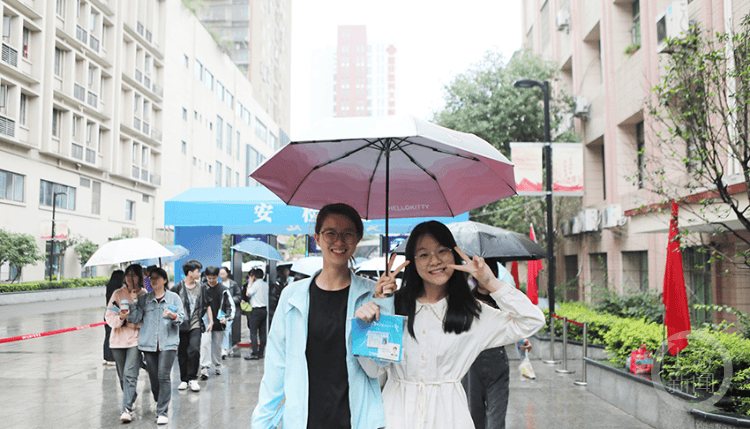 永川区,考生通过安检进入萱花中学考点.永川区,送考老师为考生加油.