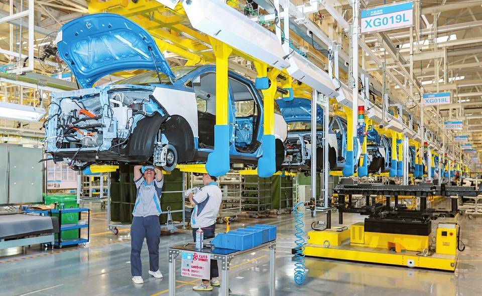 6月4日,在运城市大运新能源汽车总装车间内,技术工人正在组装新能源