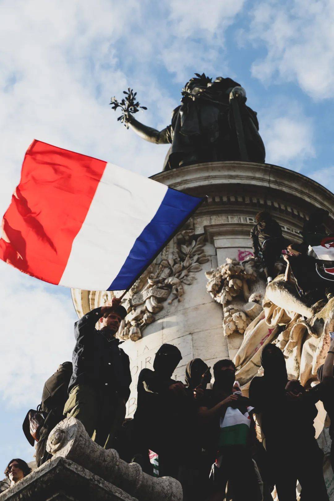 在位于巴黎的共和国广场,"新人民阵线"支持者爬上广场中央的共和纪念