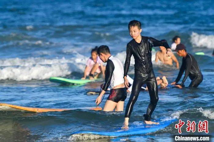 央媒看万宁|海南万宁日月湾:冲浪运动吸引人 游客多如下饺子_中国_旅游_小朋友