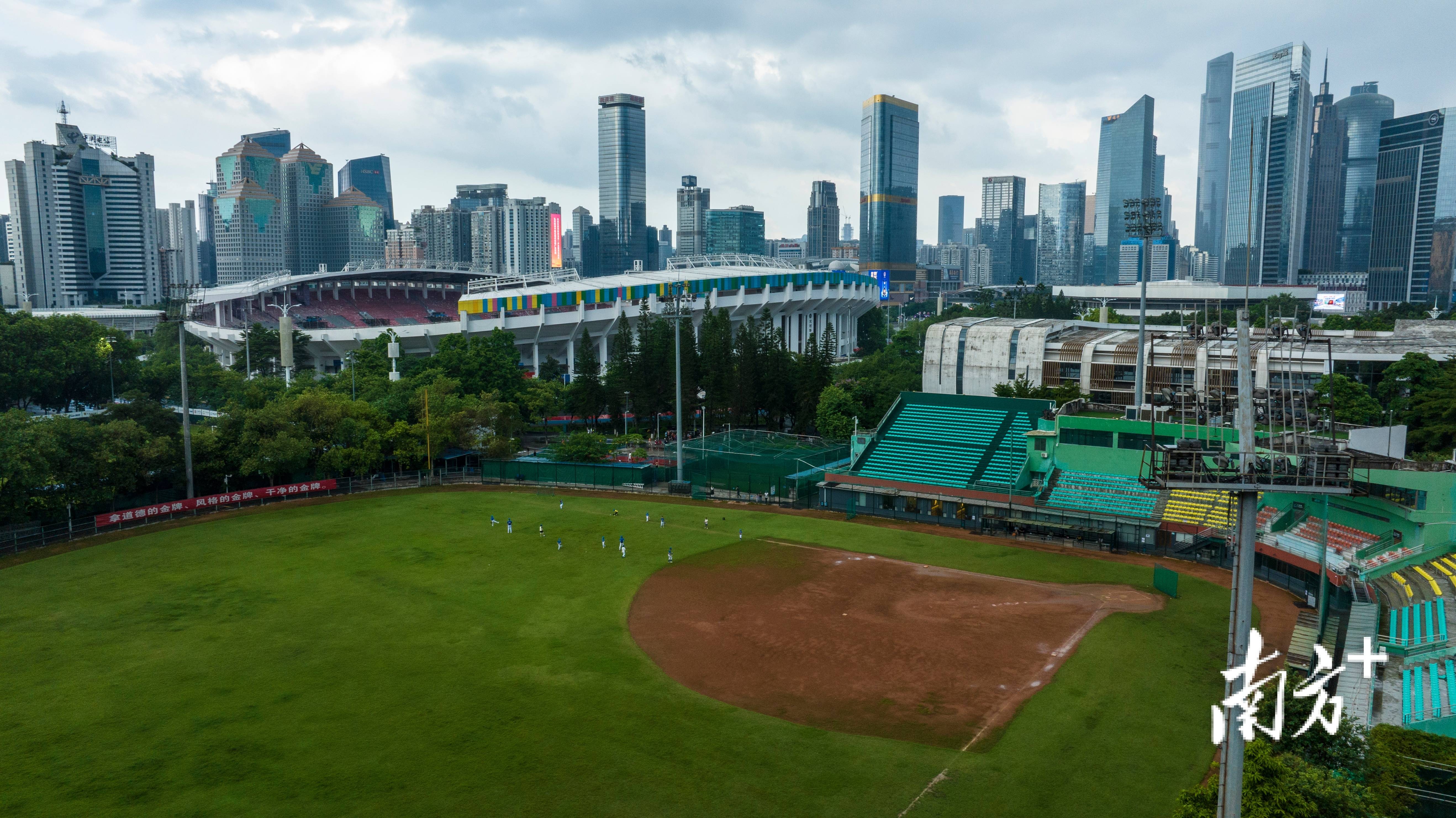 广州天河体育中心旁,一支棒球队在球场训练,远处是广州的高楼大厦.