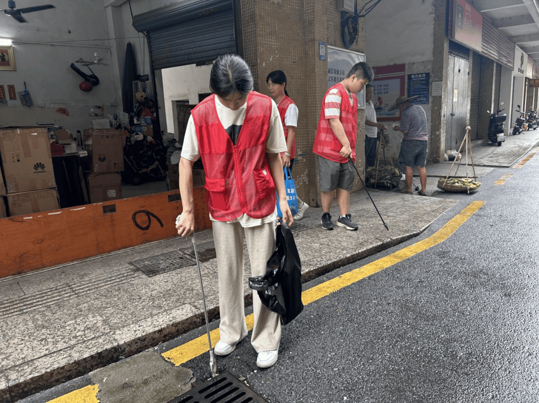 在基龙社区,志愿者们带着扫帚,簸箕等工具,开展环境卫生整治志愿服务