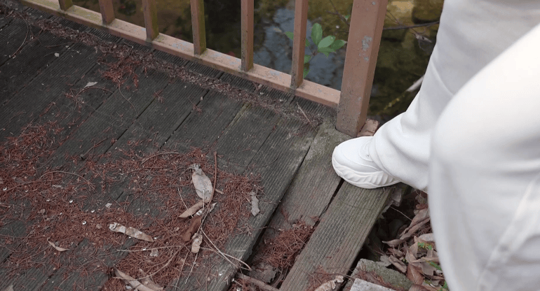 ,脚踩上去的时候我们可以看到这个平台的晃动是非常剧烈的,非常危险。我们看到这个木板,它是明显发生了松