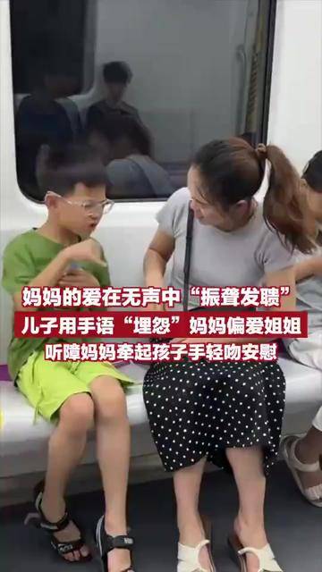 Son uses sign language to "complain" that mom favors older sister, deaf mother holds child's hand and gently kisses to comfort.