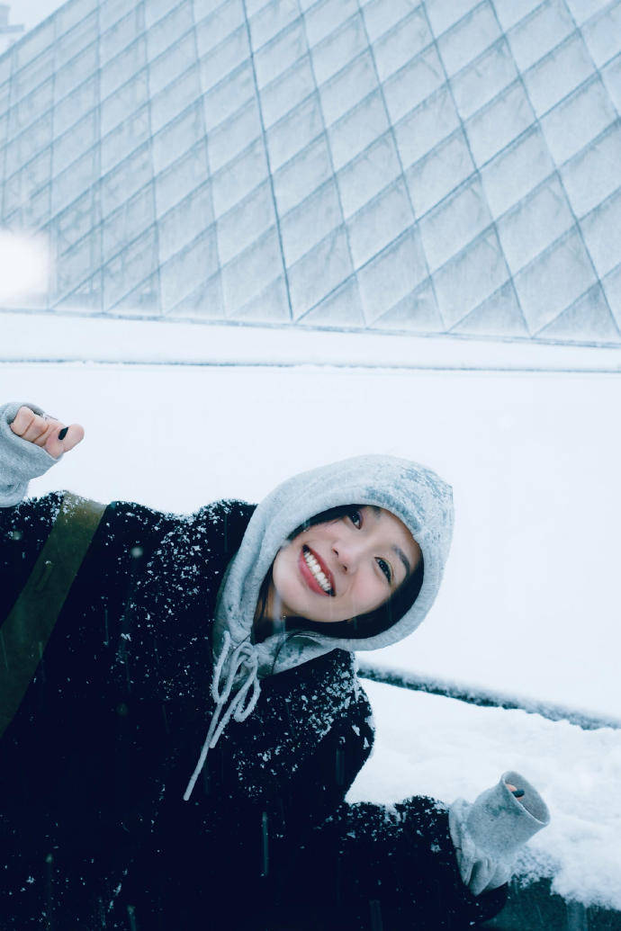 周也晒法国看雪照笑貌灿烂 穿玄色大衣五官讲求